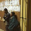 [ARCHIVO] Dos personas esperan junto a fotos de personas desaparecidas en México. 