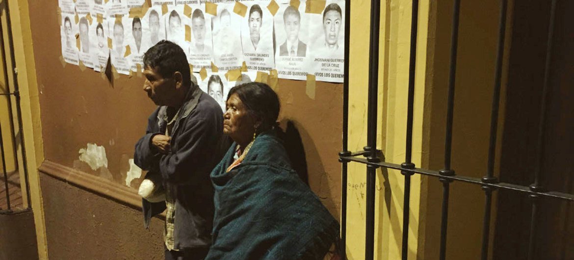 Deux Mexicains à Oaxaca sous des affiches de disparus. Photo Jeca Taudte