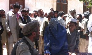 A woman registers to pick up her aid package in Kunduz city, Afghanistan, in April 2015 after escaping fighting in her district between the Taliban and government forces.
