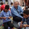 El Alto Comisonado de la ONU para los Refugiados, António Guterres, junto a dos niños sirios que juegan a la Playstation en el Centro de Identificación de Moria, en Lesbos. Foto: ACNUR/A. Zavallis
