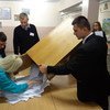 Member of a polling station committee for Belarus' presidential election empty a ballot box prior to counting in Minsk, 11 October 2015.