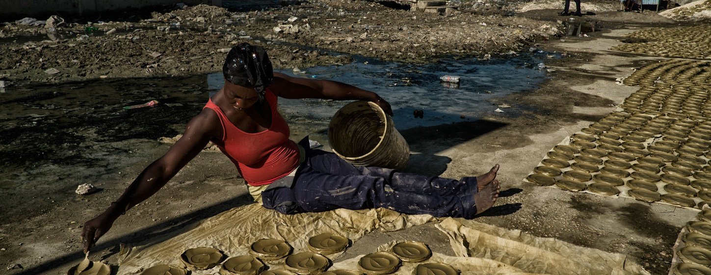 Mulher prepara bolos de barro, discos de barro, manteiga e sal que se tornaram um símbolo da pobreza extrema e fome no Haiti. 