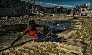 Женщина готовит "глиняный хлеб" - лепешки из глины, масла и соли, которые стали символом борьбы гаитян с голодом и бедностью