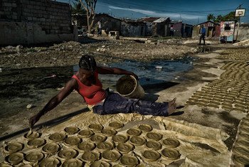 Mulher prepara bolos de barro, discos de barro, manteiga e sal que se tornaram um símbolo da pobreza extrema e fome no Haiti. 