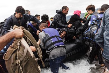 Un grupo de refugiados desembarca de un bote inflable tras alcanzar la costa de la isla griega de Lesbos. Foto: ACNUR/Achilleas Zavallis