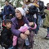 Una mujer con sus hijos busca refugio en la frontera de la ex República Yugoslava de Macedonia y Grecia. Foto: ACNUR/Mark Henley