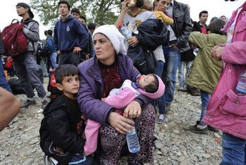 Una mujer con sus hijos busca refugio en la frontera de la ex República Yugoslava de Macedonia y Grecia. Foto: ACNUR/Mark Henley
