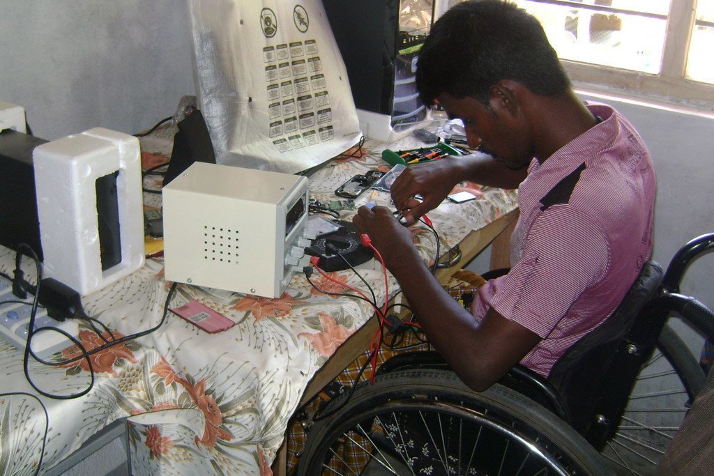 رجل من ذوي الاحتياجات الخاصة يدير شركة لإصلاح الهاتف المحمول في سري لانكا.