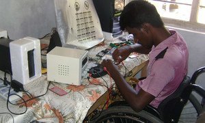 A disabled man operates a mobile phone repair business in Sri Lanka.