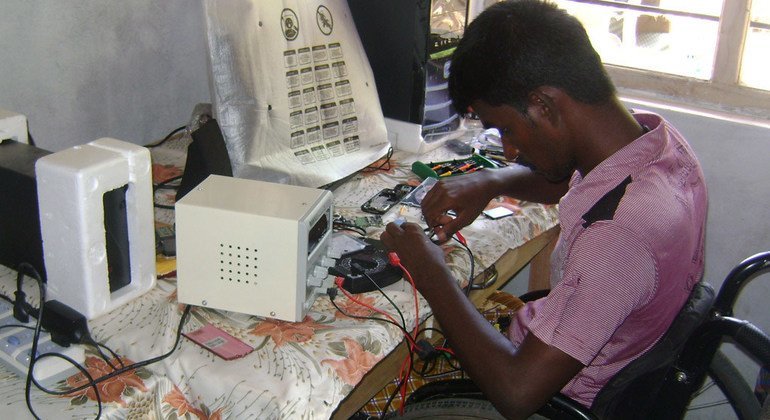 Un joven con discapacidad trabajando en una compañía de reparación de teléfonos móviles en Sri Lanka. 