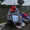 A refugee huddles up against the cold on the border between Serbia and Croatia.