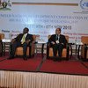 Four men in suits sit on a stage at the United Nations Development Cooperation Forum High-Level Symposium in Uganda, 2015.