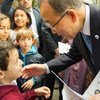 Secretary-General Ban Ki-moon (right) greets a young boy at the Centre Tenda Di Abramo in Rome, during a visit on 17 October 2015.