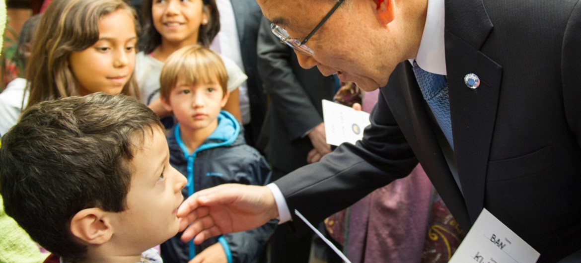 Secretary-General Ban Ki-moon (right) greets a young boy at the Centre Tenda Di Abramo in Rome, during a visit on 17 October 2015.