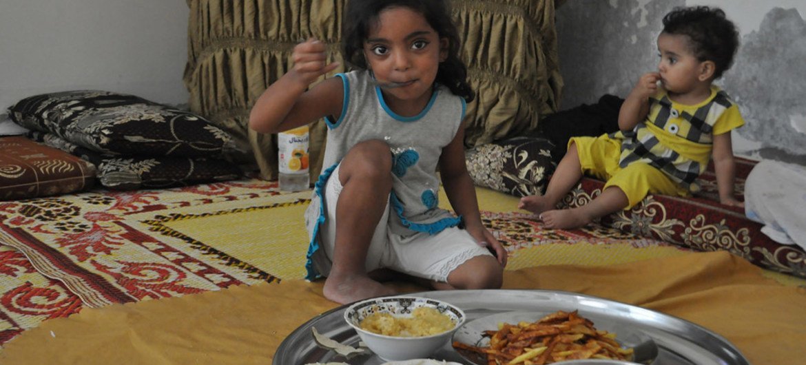 طفلان من المشردين داخليا في حمص، سوريا، يتناولان وجبة طعام. المصدر: برنامج الغذاء العالمي/ عبير عطيفة