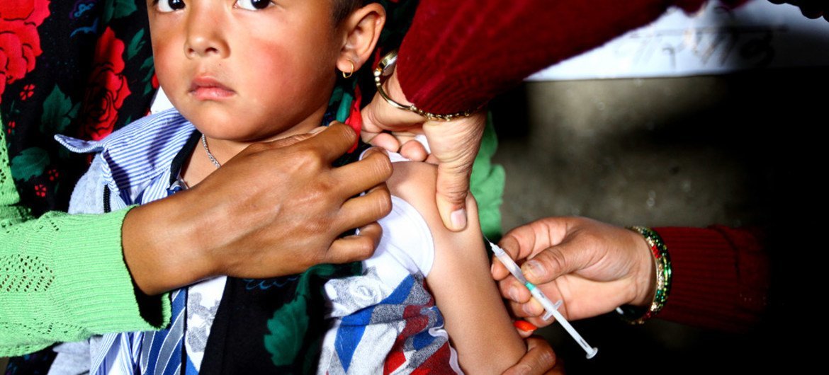 Un jeune garçon est vacciné contre la rougeole et la rubéole dans un centre de santé du district de Gorkha, au Népal.