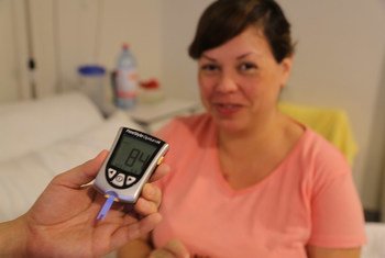 Une femme se fait tester son taux de glucose dans le sang. 