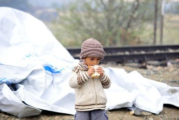 A young child eats a sandwich next to the tarpaulin that serves as a makeshift shelter, close to the town of Gevgelija, Former Yugoslav Republic of Macedonia, on the border with Greece (September 2015).