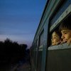 أطفال ينظرون من نافذة القطار في مركز لاستقبال اللاجئين والمهاجرين في جمهورية مقدونيا اليوغوسلافية السابقة. المصدر: اليونيسف / اشلي جلبرتسون السابع
