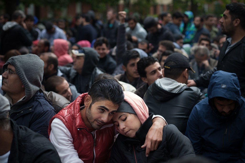 A Berlin, un couple parmi des migrants attendant d'être enregistrés comme demandeurs d'asile. Si les pays ont le droit de déterminer leurs propres politiques migratoires, ils doivent le faire dans le respect des droits de l'homme, a dit le chef de l'ONU