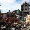 A woman and her baby amid debris and other destruction caused by Super Typhoon Haiyan in the Philippines.