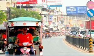 Tuk-tuk drivers dressed in orange participate in a parade on 25 October 2015 in Phnom Penh, Cambodia, to raise awareness and promote ending violence against women and girls in their community.