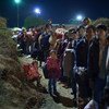 Refugees and migrants, mainly from Afghanistan, Iraq and the Syrian Arab Republic, wait in a long queue at nightfall, at the Opatovac registration and transit centre, on the border between Croatia and Serbia.
