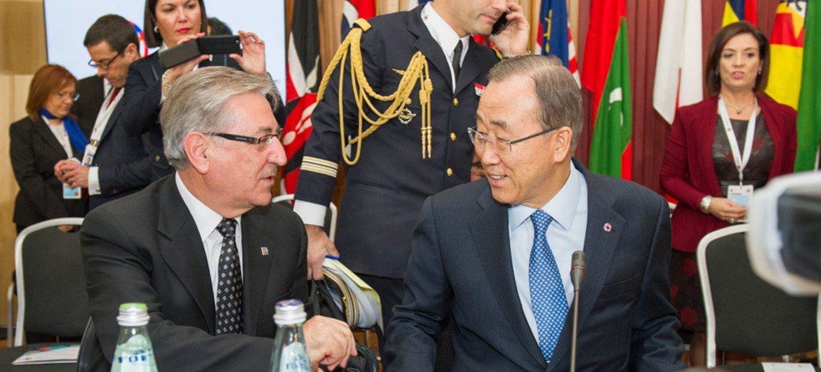 Le Secrétaire général Ban Ki-moon (à droite) discute avec le Commissaire européen pour l'environnement, les affaires maritimes et la pêche, Karmenu Vella, lors d'un Sommet du Commonwealth à Malte. Photo ONU/Rick Bajornas