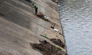In Pasig, Philippines, a city worker cleans the Manggahan Floodway, built to reduce flooding along the Pasig River during the rainy season.