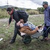 أحد العاملين الإغاثيين يساعد لاجئا سوريا فقد ساقه مما أدى إلى إصابته بالإعاقة، وذك على الحدود بين مقدونيا وصربيا