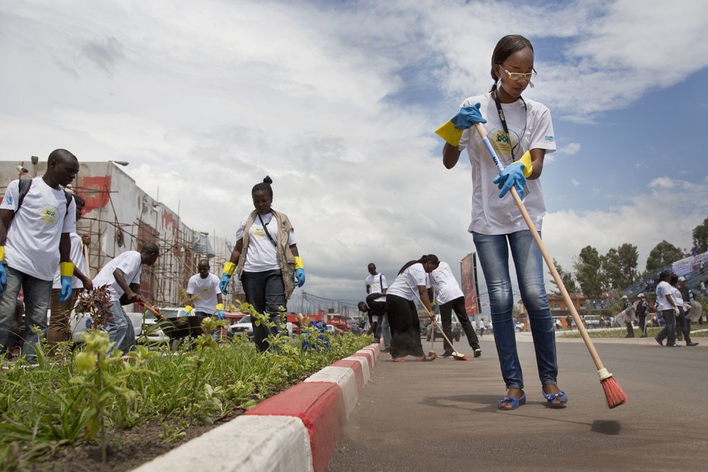 Des Volontaires des Nations Unies et des membres d'organisations locales nettoient une route très fréquentée dans le cadre des activités de la Journée internationale des Volontaires à Goma, dans l'est de la République démocratique du Congo (RDC)