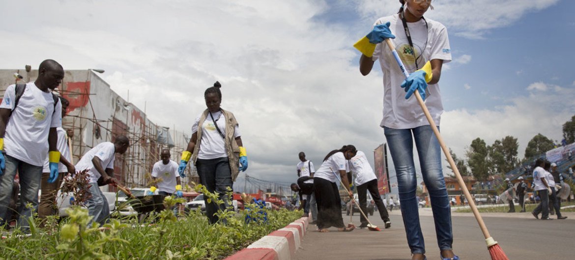 UN Volunteers and members of local organizations clear a busy road as part of activities for International Volunteer Day in Goma, eastern Democratic Republic of the Congo (DRC).