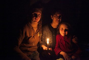 A woman and her daughters sit in candlelight in a bomb shelter on the outskirts of the city of Debaltsevo in Donetsk Oblast, Ukraine.