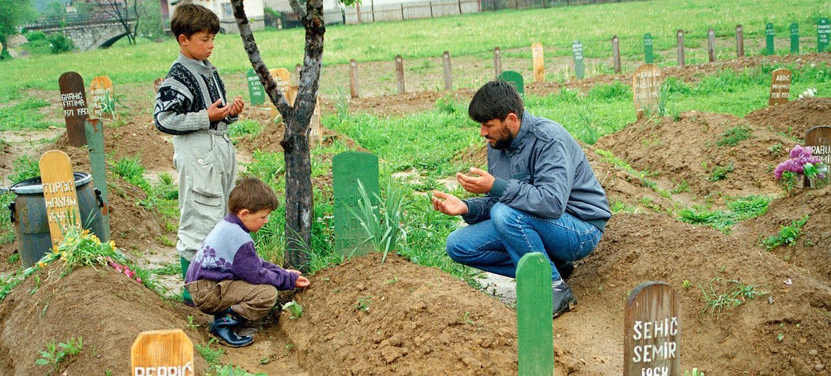 在波黑，一位穆斯林在儿子的墓前哀悼。他的儿子死于1995年的斯雷布雷尼察种族灭绝事件。联合国图片/John Isaac