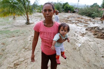 En octobre 2015, une mère avec son enfant évacue la ville de Laur, aux Philippines, à cause d'un typhon.