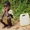 A little girl waits to fill her water container in the village of Kikonka, Bas-Congo province, Democratic Republic of Congo.