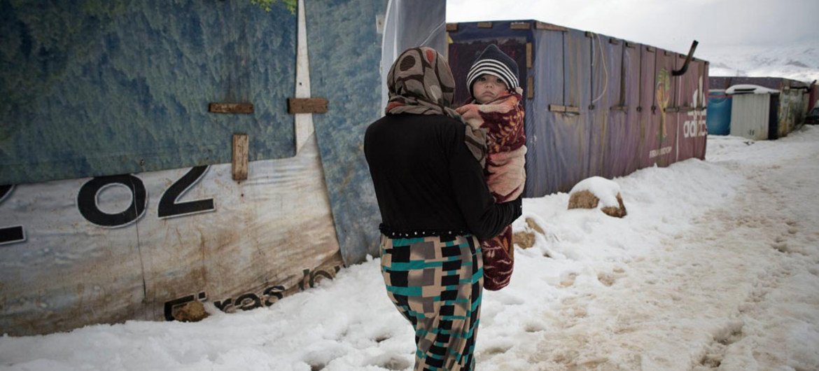 في يناير 2015، امرأة تحمل رضيعا وسط الثلوج في مخيم للاجئين، في وادي البقاع. المصدر: اليونيسف / UNI179012 / رومنزي