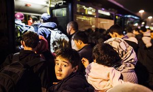 Dans un port en Grèce, un jeune garçon et sa famille rejoignent d'autres réfugiés et migrants qui tentent de monter à bord d'un autobus qui les transportera au centre d'Athènes. (archives)