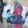 Displaced Syrians receive UNICEF winter clothing kits.