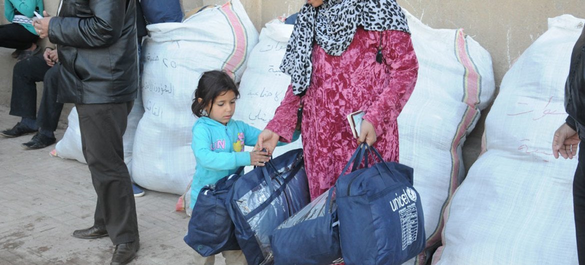 Displaced Syrians receive UNICEF winter clothing kits.
