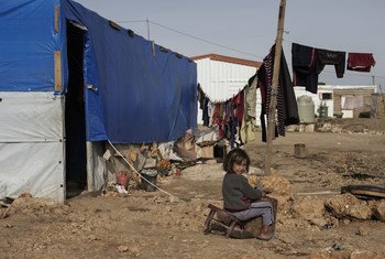在黎巴嫩贝卡谷地一个非正式叙利亚难民定居点，一名叙利亚难民女孩坐在营地帐篷外的破椅子上。