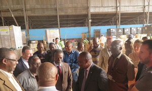 Le Représentant spécial et chef de la Mission multidimensionnelle intégrée des Nations Unies en République centrafricaine (MINUSCA), Parfait Onanga-Anyanga (cravate rouge) et des membres du corps diplomatique visitent un entrepôt de matériel de vote à l'aéroport de Bangui le 23 décembre 2015.