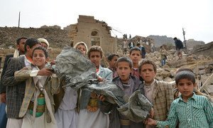 Boys hold a large piece of twisted metal near homes that were destroyed in an air strike, in Okash Village, near Sana’a, the capital of Yemen.