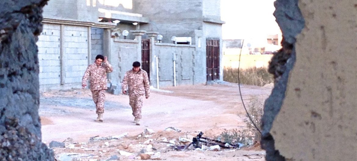 Deux soldats des forces opérant sous le gouvernement libyen basé à Tripoli marchant dans les rues désertes de Bin Jawad, près de l'important port pétrolier de Sidra.