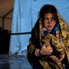 فتاة صغيرة تقف خارج خيمة في مركز استقبال اللاجئين والمهاجرين في غيفيغليا، جمهورية مقدونيا اليوغسلافية سابقا. من صور اليونيسيف/أشلي غلبرتسون.
