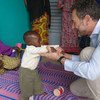 Regional Humanitarian Coordinator for the Sahel, Toby Lanzer, plays with a child at a Gao malnutrition treatment center in Mali.