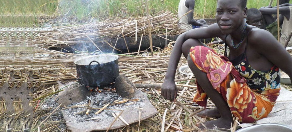 An internally displaced woman seeking refuge from the ongoing violence in the swamps of Unity state, cooks her last supply of sorghum.
