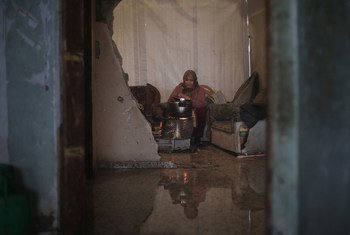 In the town of Beit Hanoun in northern Gaza, a Palestinian woman prepares food for her family inside her bombed out house, damaged in the 2014 hostilities. Her house suffers from waters leaks and is engulfed in freezing winds as a result of the latest win