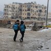 In Syria, two boys head home after school in East Aleppo in a snow day for the city.