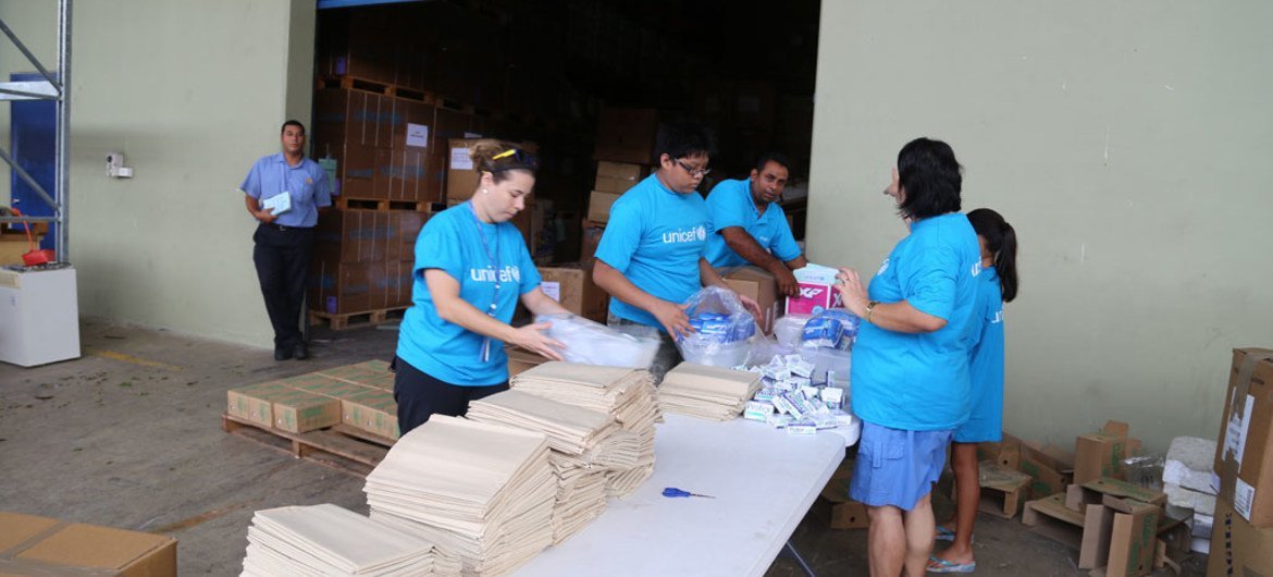 Le personnel de l'UNICEF et des bénévoles emballent des kits WASH (contenant de l'eau et des produits d'assainissement et d'hygiène), ainsi que des fournitures scolaires dans l'entrepôt de l'UNICEF à Suva, dans les îles Fidji, suite au passage du cyclone 